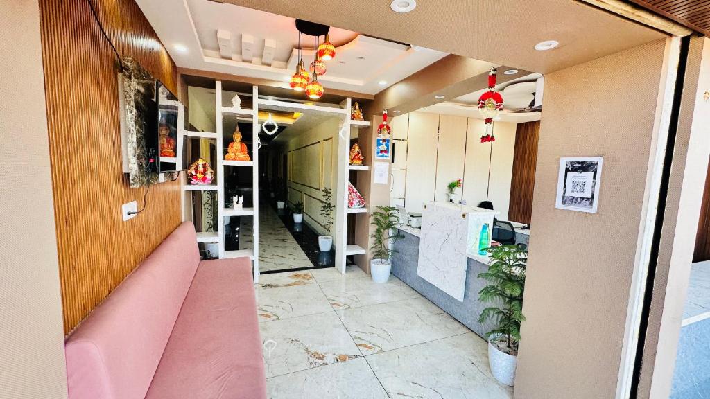 una vista del corridoio di una stanza con una panca rosa di Himtaara Hotel a Islāmnagar