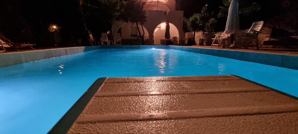 una piscina notturna con luci blu di Seaside studio with swimming pool & parking #3 a Kassandra (Kassandria)