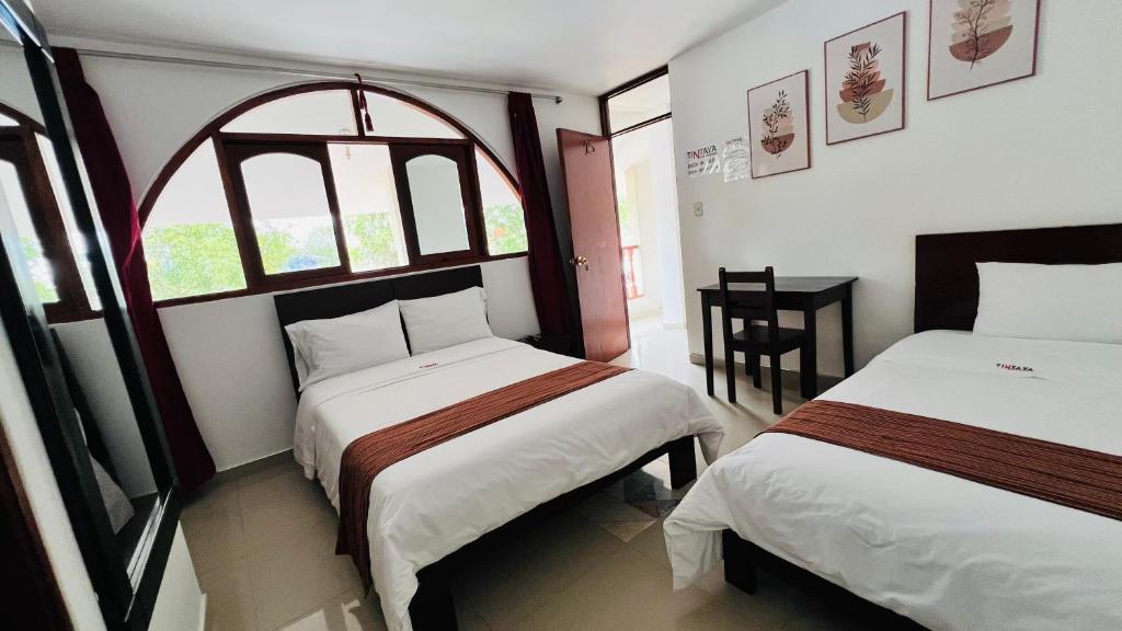 a bedroom with two beds and a window at Tintaya Hotel Chachapoyas in Chachapoyas