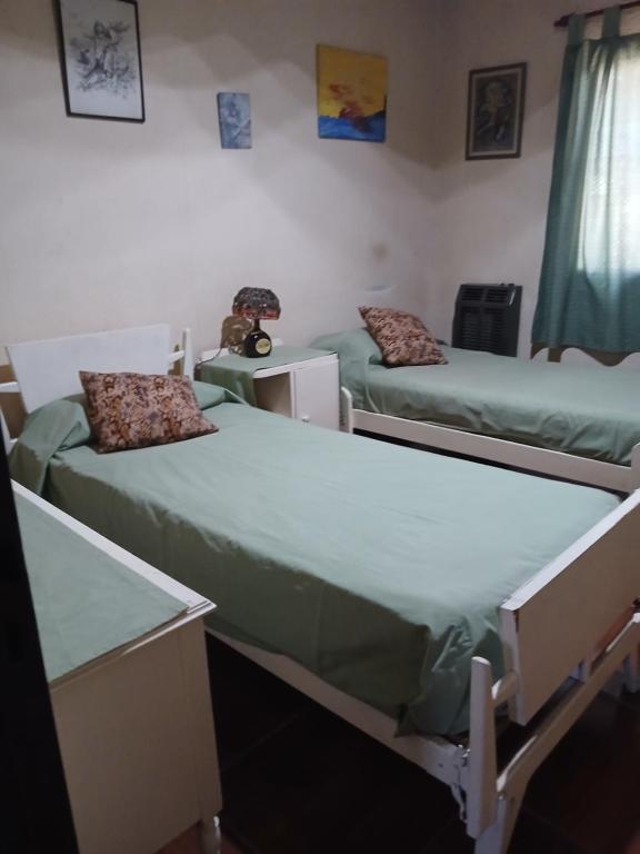 a room with two beds and a table at Las Gemelas in Rosario
