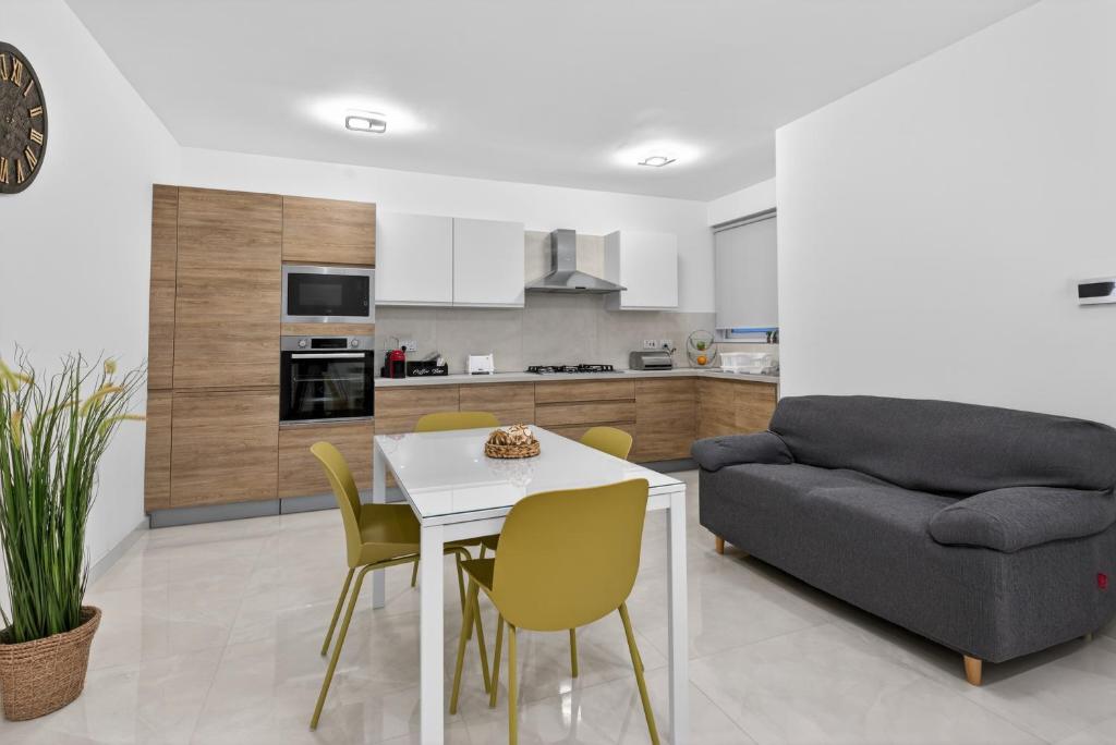 a kitchen and living room with a table and a couch at Contemporary Retreat in St. Paul's Bay