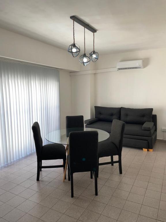 un soggiorno con un divano, un tavolo e delle sedie di B&J Apart Bahía a Bahía Blanca