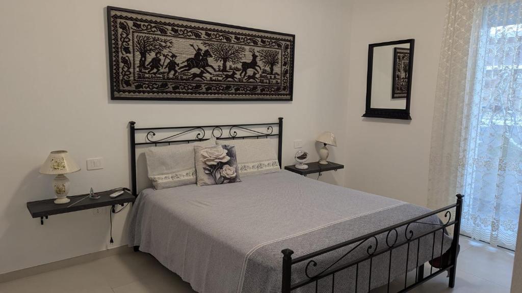 a bedroom with a bed and a picture on the wall at Domu S'Aratzia - Vicino al mare - con parcheggio privato in Quartu Sant'Elena