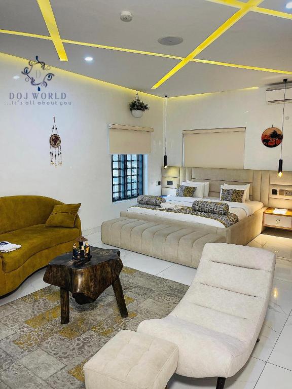 ein Schlafzimmer mit zwei Betten, einer Couch und einem Tisch in der Unterkunft DOJ WORLD in Ikeja