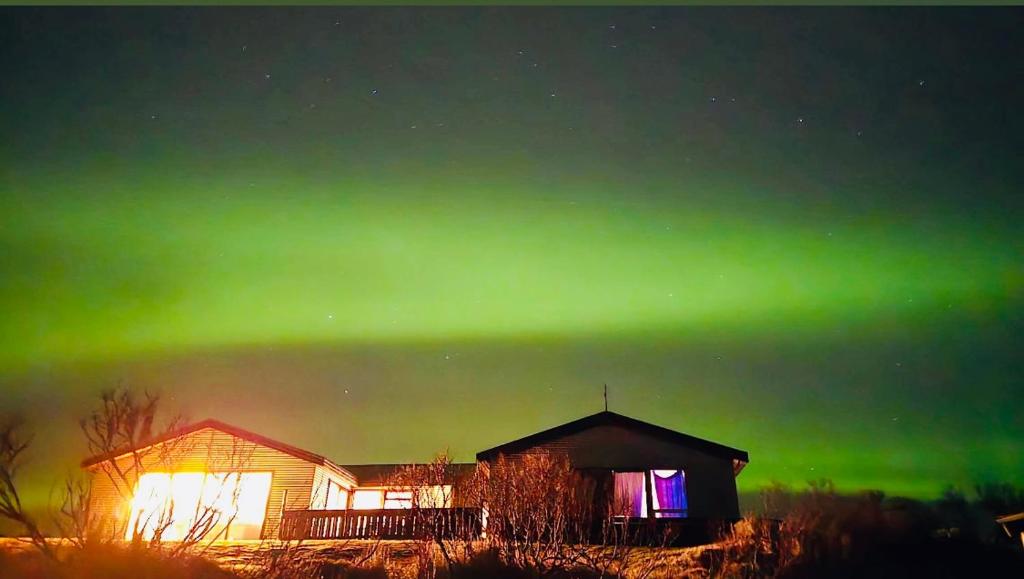 an image of the aurora borealis over a house at Vestra-Fíflholt 2 herbergja íbúð, fyrir allt að 8 gesti in Hvolsvöllur