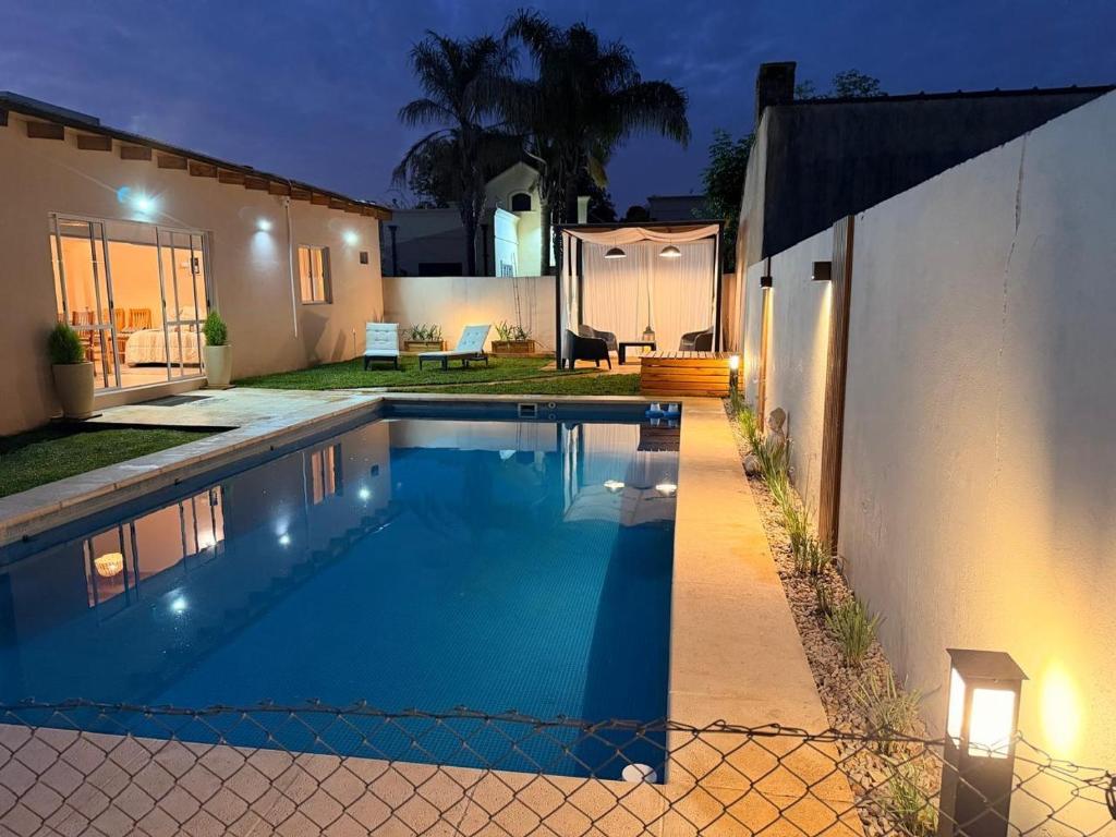 a swimming pool in front of a house at night at QUINTA BELEN Cañuelas in La Porteña