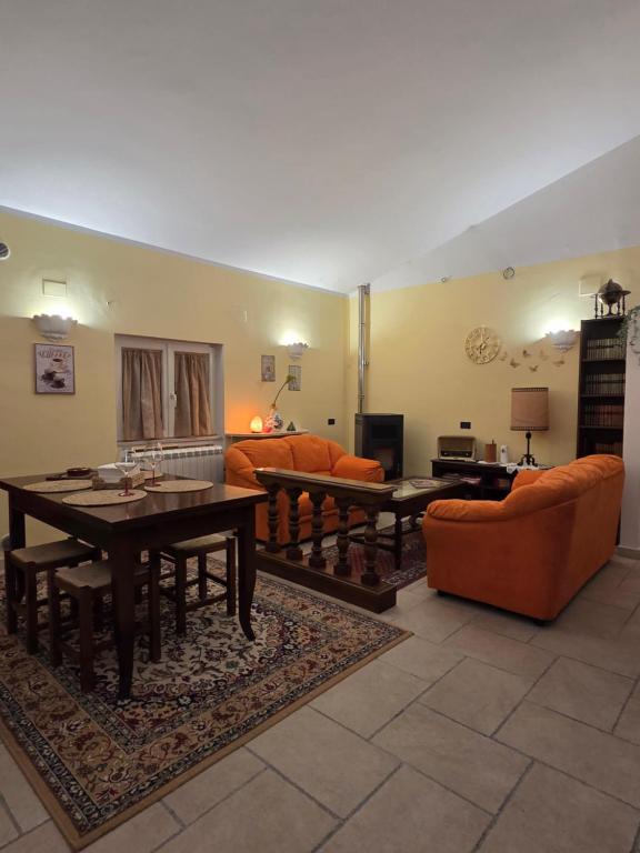 a living room with orange furniture and a table at Farfalle in fiore Guesthouse in Roccasecca