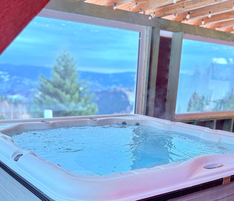 een jacuzzi met een groot raam in een huis bij Hytta Eliaszówka in Piwniczna