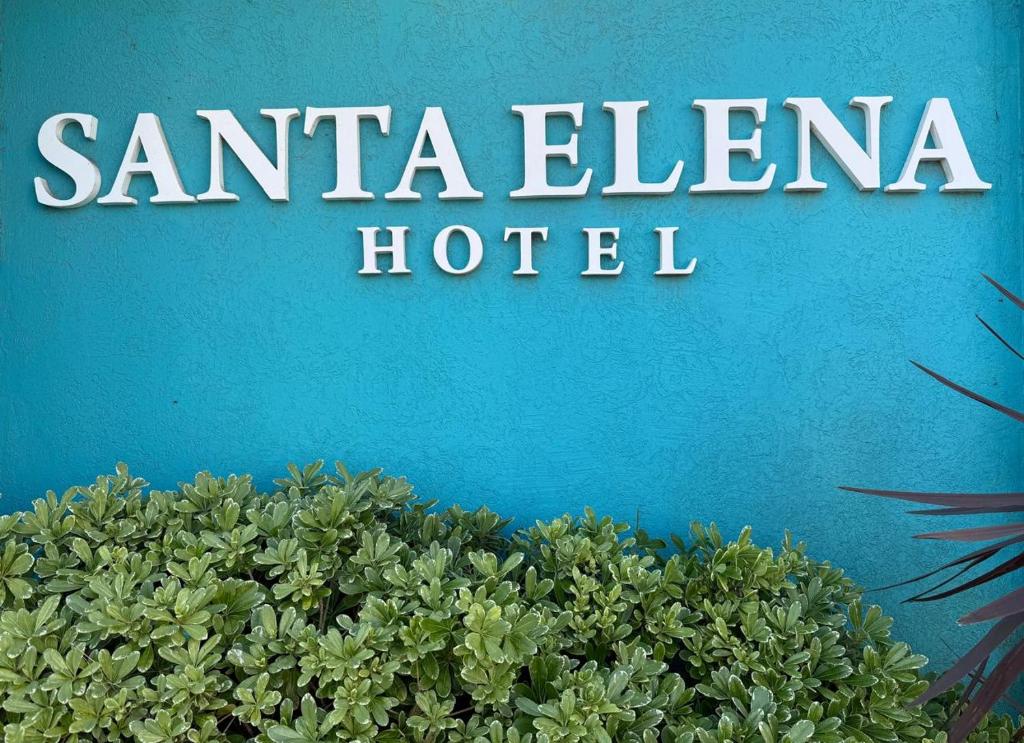 Een bord van een Santa Elena Hotel naast een struik. bij Hotel Santa Elena in San Clemente del Tuyú