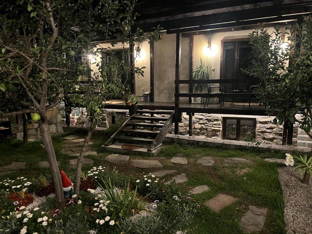 a house with a bench in the yard at night at Rilski Chardak in Sapareva Banya