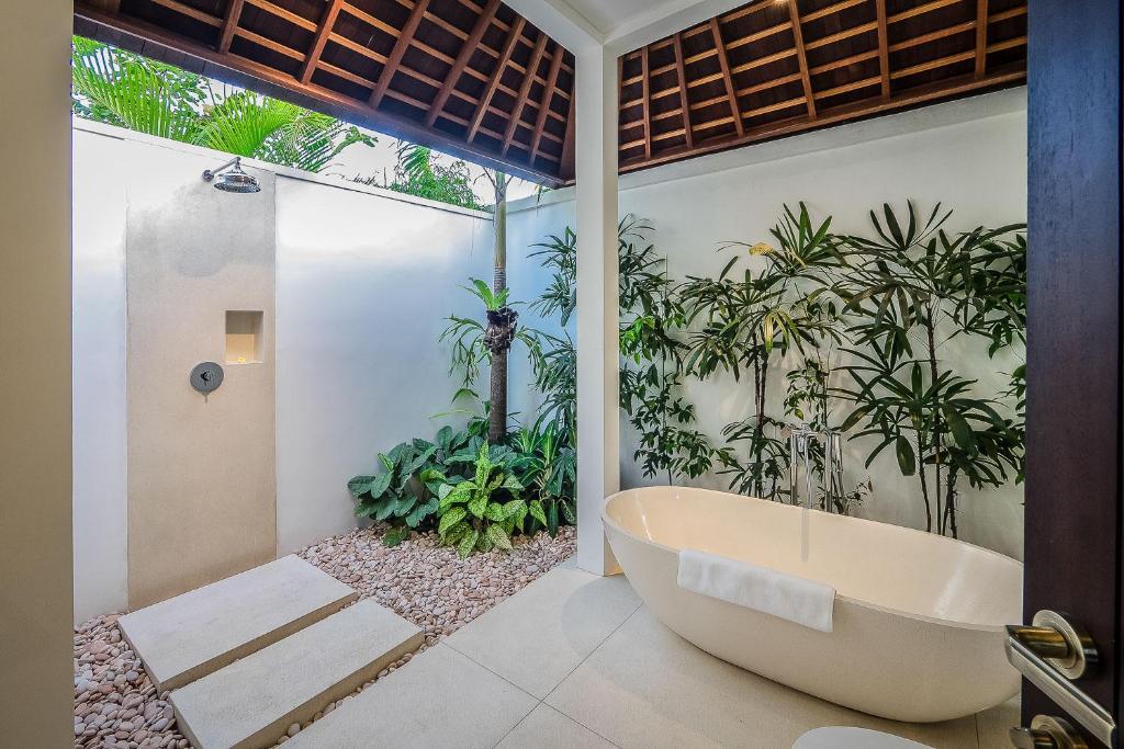 a bath tub in a bathroom with plants at Sayan Villas in Hikkaduwa