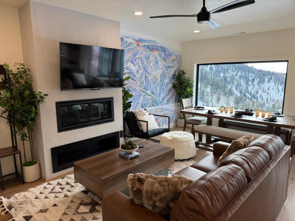 een woonkamer met een bank en een open haard bij Luxe Escape - At Powder Mountain in Sundown Condominiums at Powder Mountain
