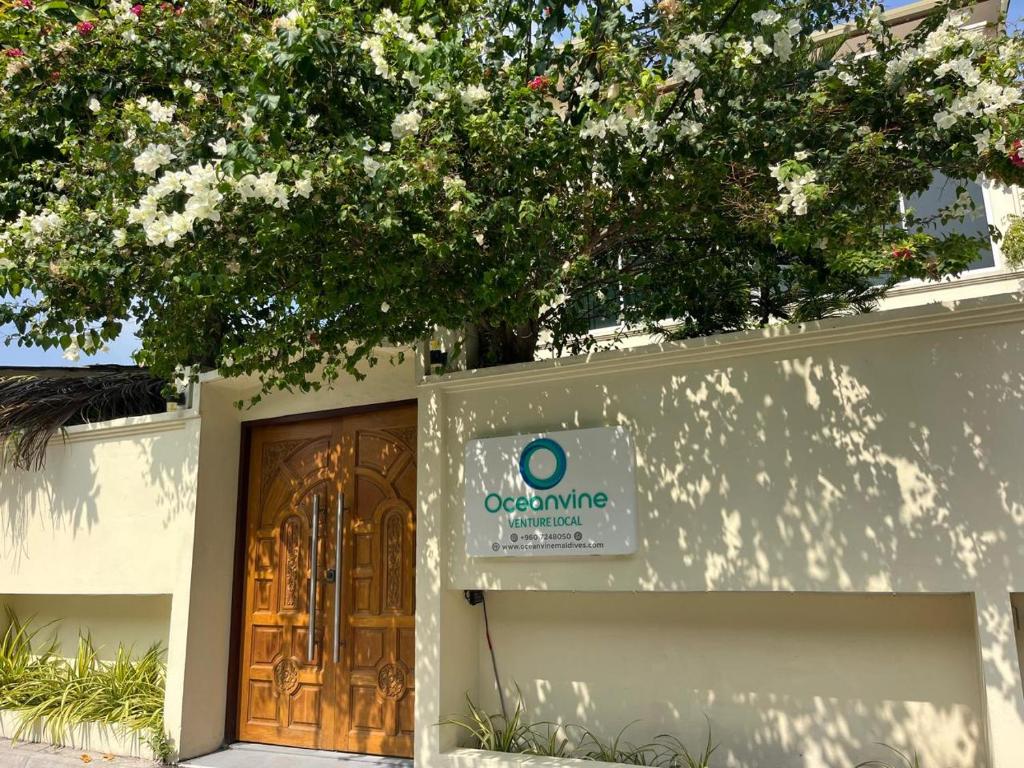 a building with a door and a tree at Oceanvine in Mahibadhoo