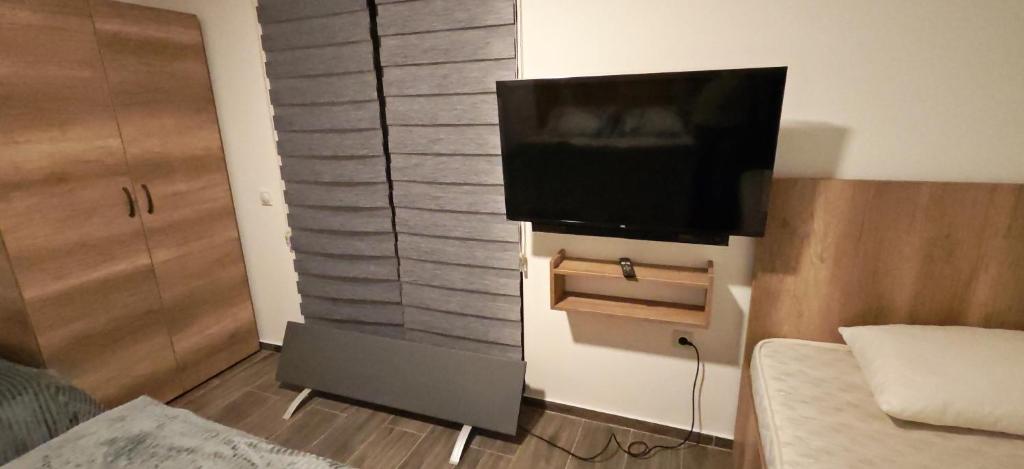 een flatscreen-tv aan een muur in een slaapkamer bij Suncani Breg in Crni Vrh