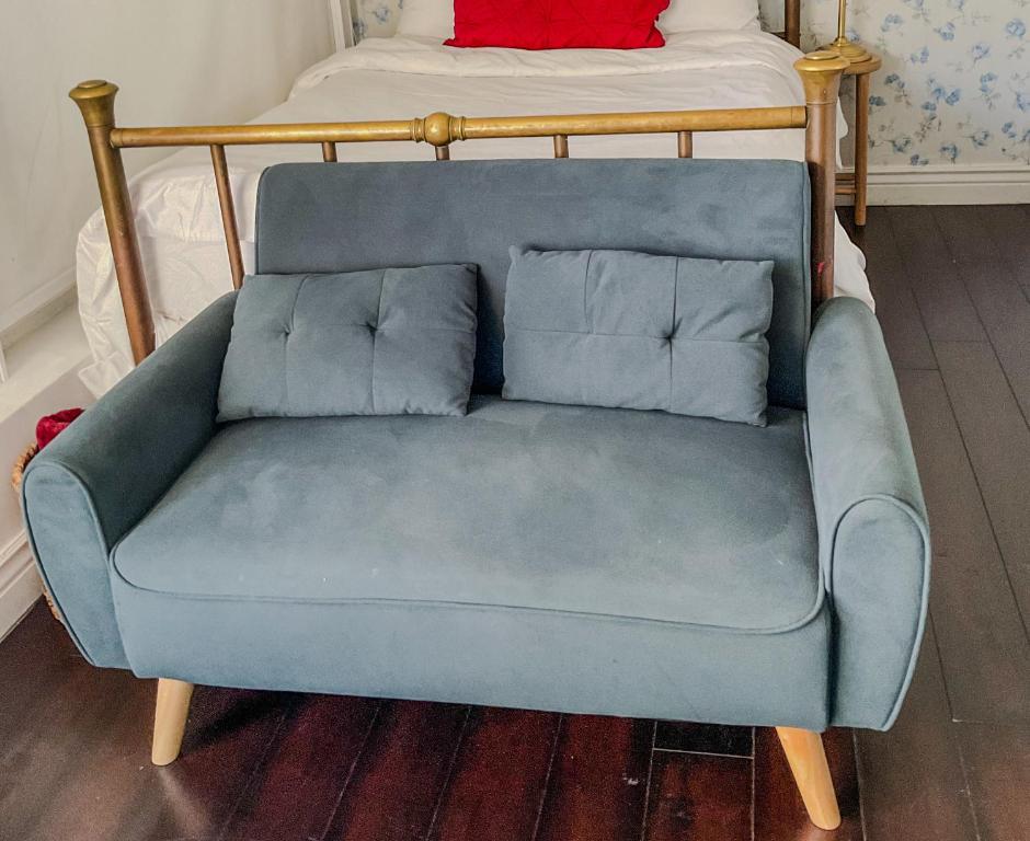 een blauwe bank met twee kussens op een bed bij Lodgings by Lisa in Cooper City