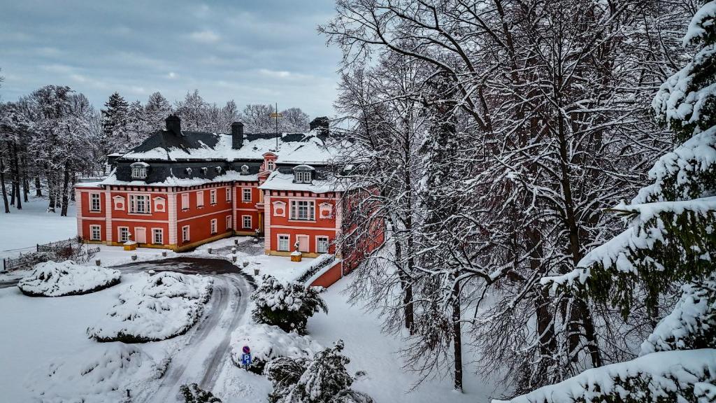 a large red house with snow on it at Pałac Spiż Miłków koło Karpacza in Karpacz