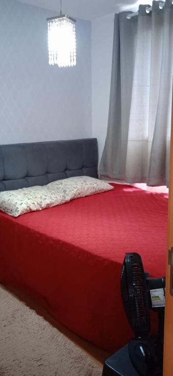 a bedroom with a bed with a red mattress and a window at Apartamento Próximo a Arena Pantanal in Cuiabá