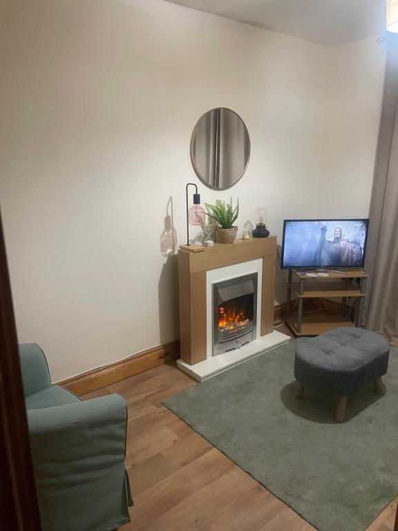 een woonkamer met open haard en tv bij Central Clonakilty House in Clonakilty