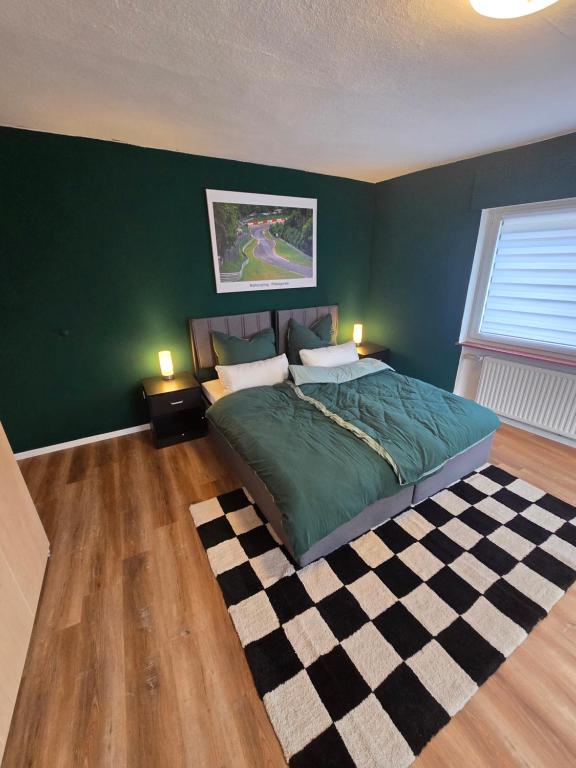 ein Schlafzimmer mit einem Bett und einer grünen Wand in der Unterkunft GreenHell Stays in Adenau