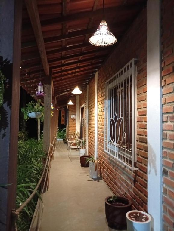 a hallway with a brick wall and a ceiling with a light at Casa Beija Flor in Itacaré
