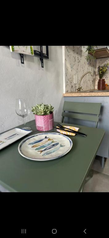 een plaat op een tafel met een plant erop bij Bujanvilla in Tarifa