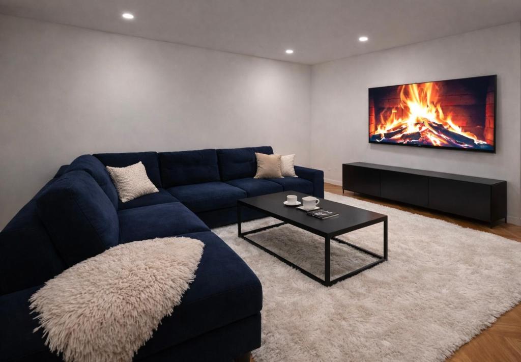 a living room with a blue couch and a fireplace at Ember Residence Spacious 2BR Apartment near Eternal Flame in Sarajevo