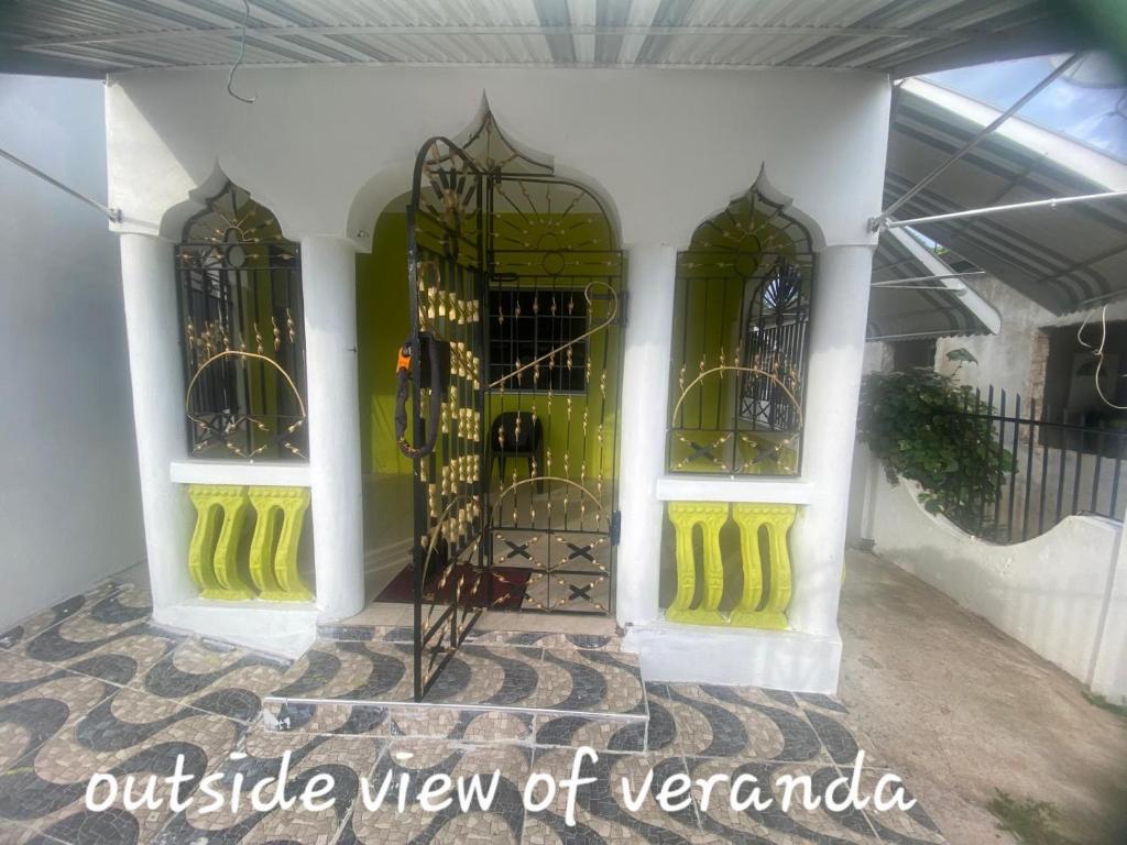 an entry way of a building with green doors at Bella's Cottage in May Pen
