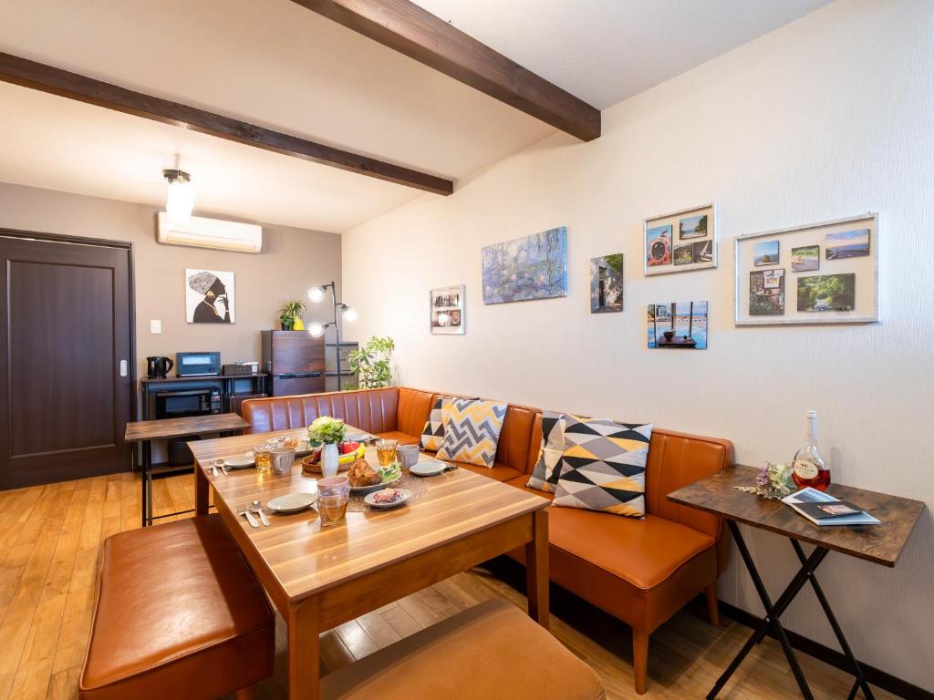 een woonkamer met een bank en een tafel bij ゲストハウス海と石 in Takamatsu