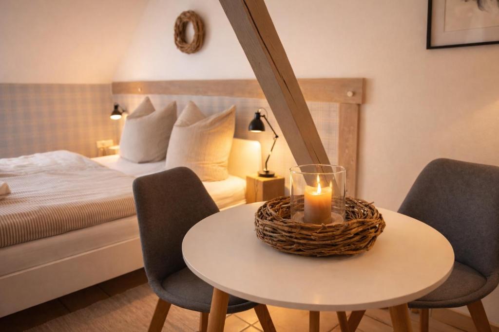 a room with a bed and a table with a candle on it at Weberhof - Münster 3 in Münster
