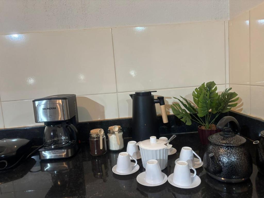 eine Küchentheke mit Kaffeemaschine und Kaffeetassen in der Unterkunft Tríade Chalé da Canastra 2 in São Roque de Minas