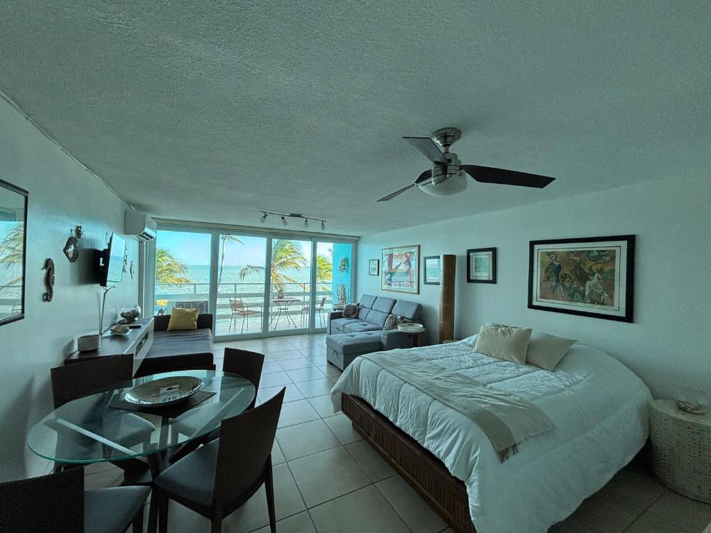 a bedroom with a bed and a living room with a table at Ocean view Studio Marina Lanais in Fajardo