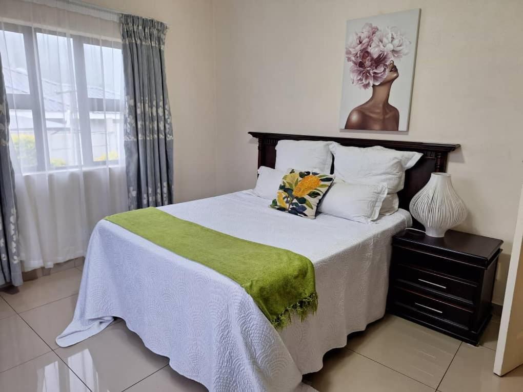 une chambre avec un lit avec une couverture verte dans l'établissement Valley Rest, à Mbabane