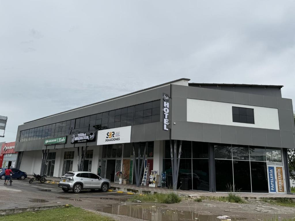 een gebouw met een auto geparkeerd op een parkeerplaats bij Tierra Bendecida Hotel Boutique in Villavicencio