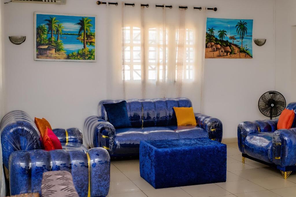 een woonkamer met twee blauwe banken en stoelen bij Villa Bernadette aéroport in Pointe-Noire