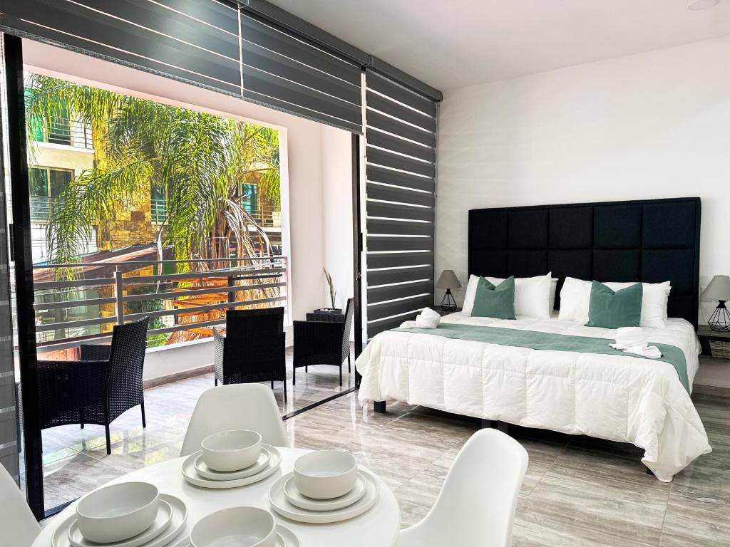 ein Schlafzimmer mit einem großen Bett und einem Balkon in der Unterkunft SILVERSANDS Hotel Boutique - 5Th Ave in Playa del Carmen