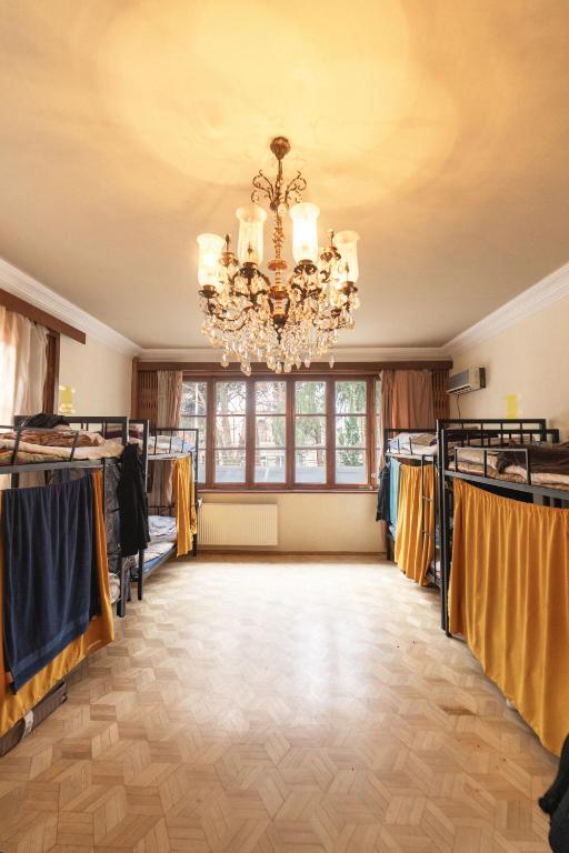 a large room with a chandelier and clothes racks at European Backpackers in Tbilisi City