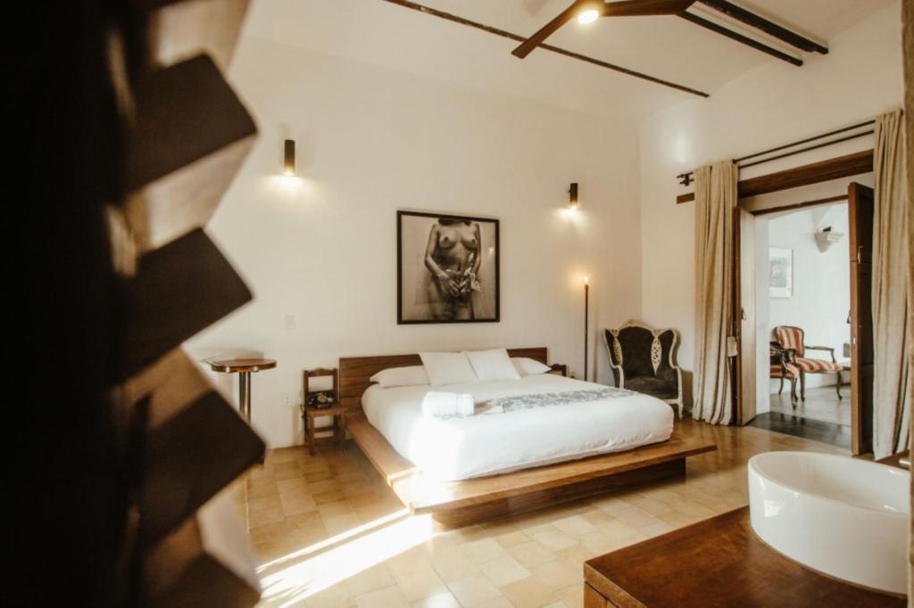 een slaapkamer met een bed en een badkamer met een bad bij Hotel Sin Nombre in Oaxaca City