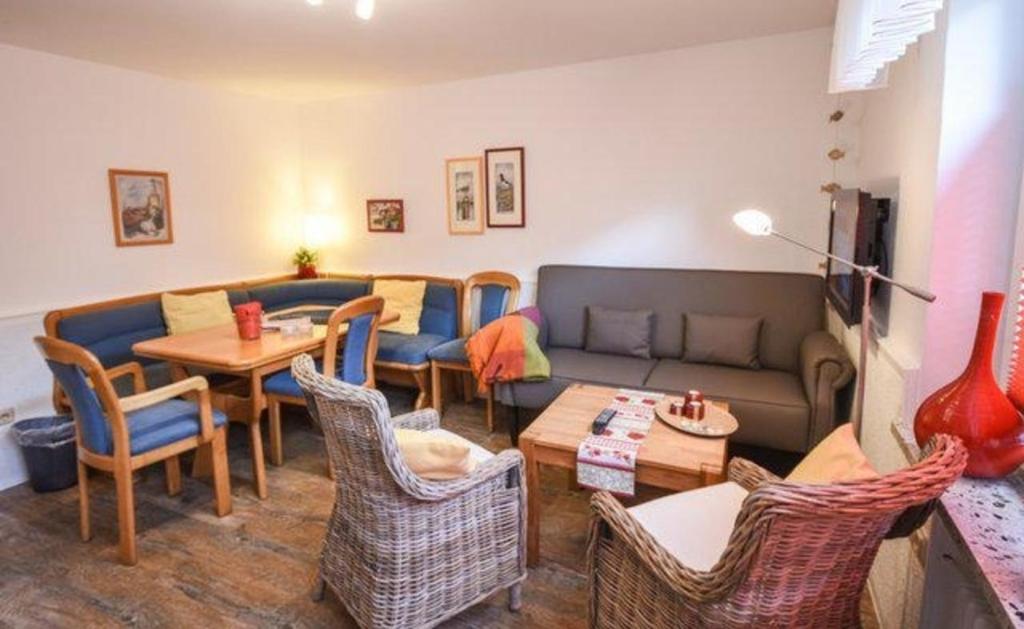 un soggiorno con un divano, un tavolo e delle sedie di Haus Seerose, Nr 8 a Baltrum