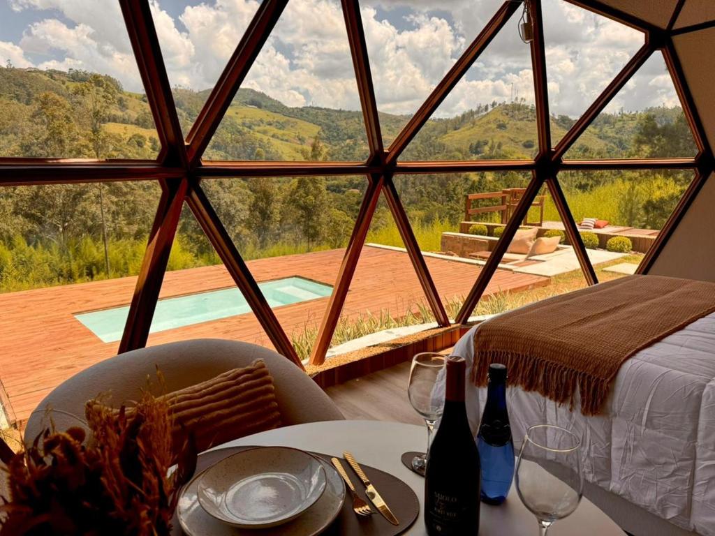 a dining table with a view of a room with a window at Exclusive Cabanas BOLHA LUXO in Serra Negra