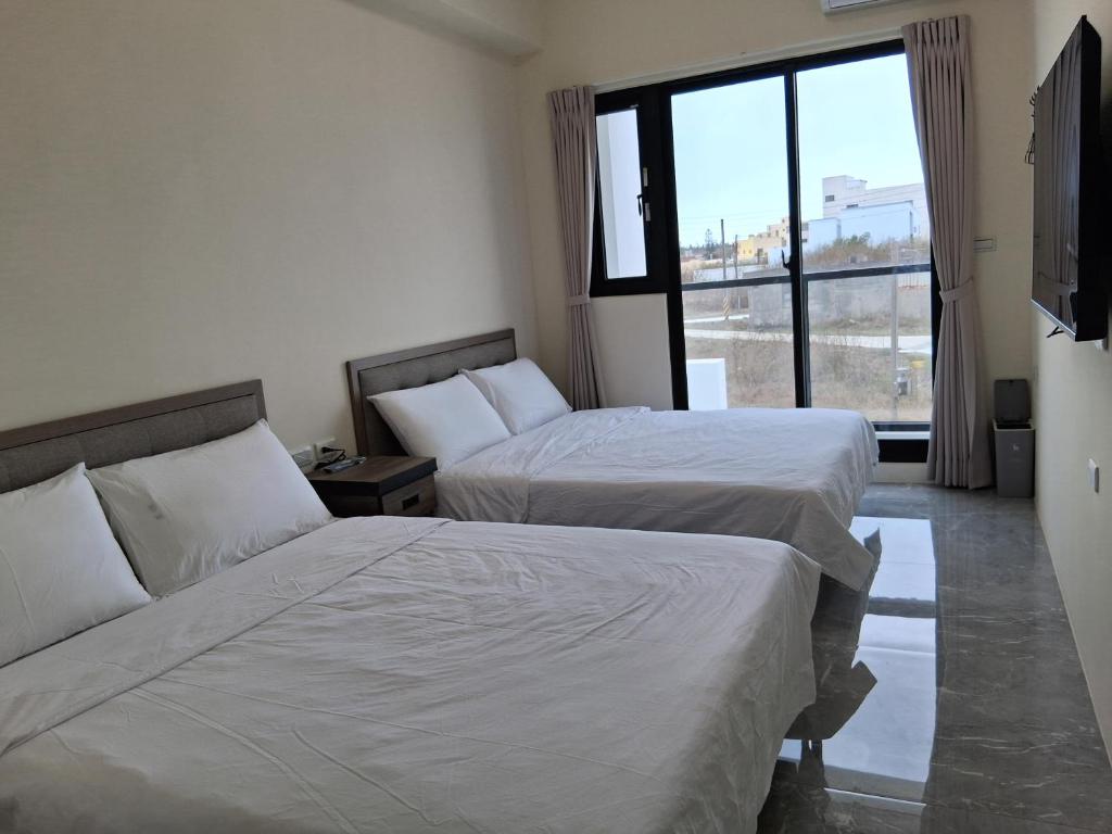 een hotelkamer met twee bedden en een raam bij 星輝漫旅 in Magong