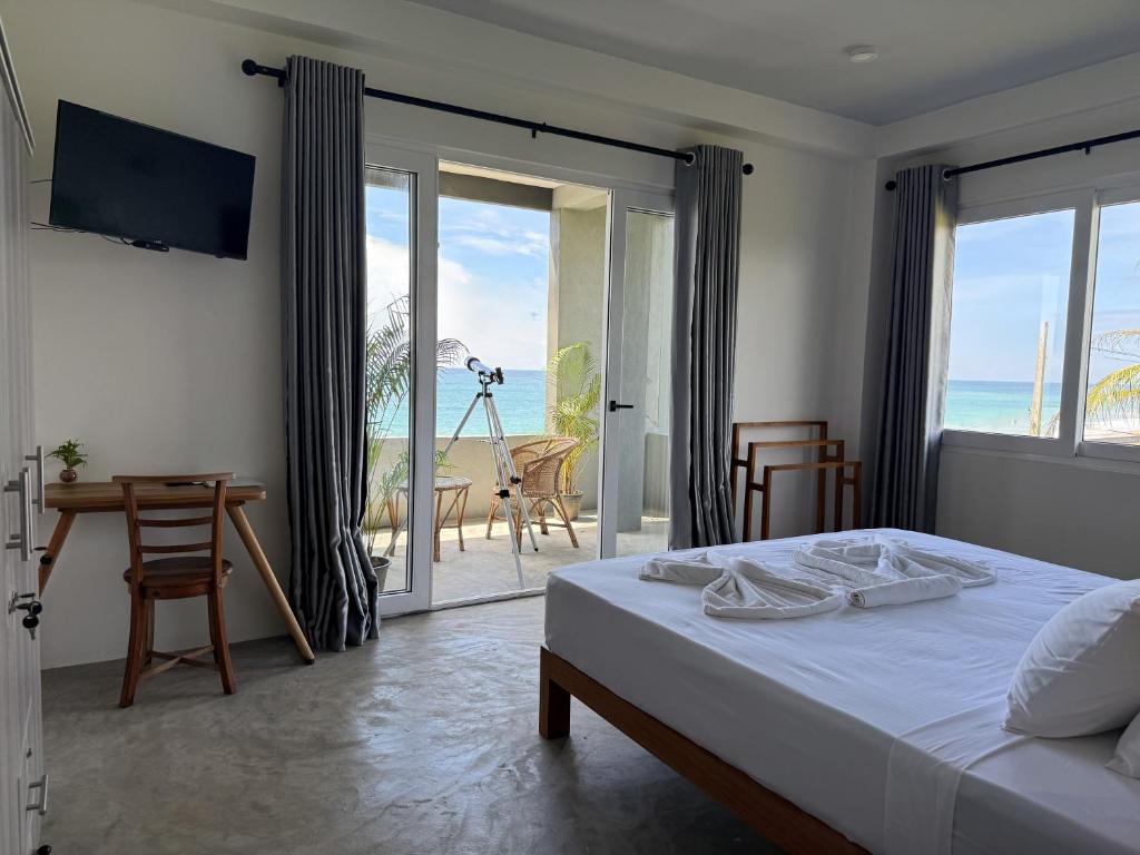 a bedroom with a bed and a view of the ocean at Goalie Beachfront Resort in Hikkaduwa