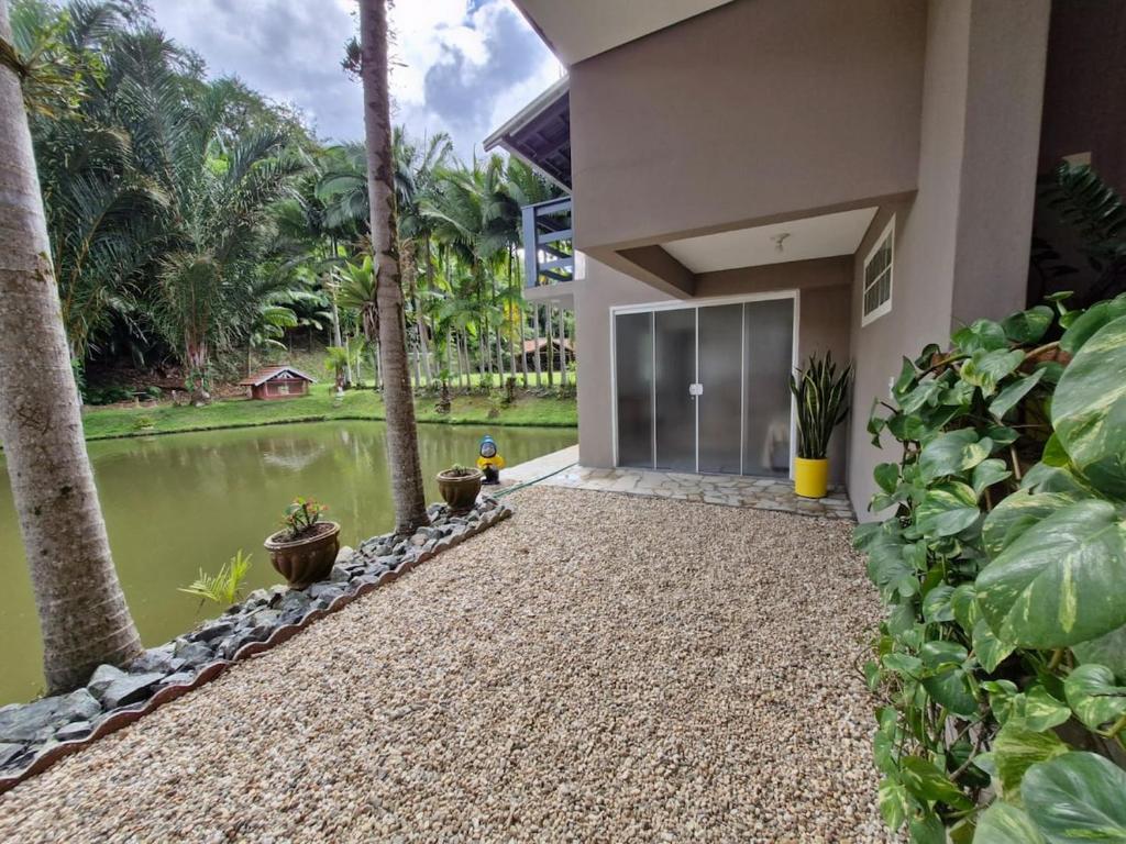a house with a pond in front of it at Pousada a 500 metros do Pico Malwee in Jaraguá do Sul