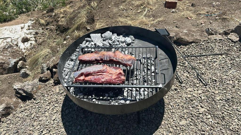 twee stukken vlees koken op een grill bij ecolodge in San Pedro