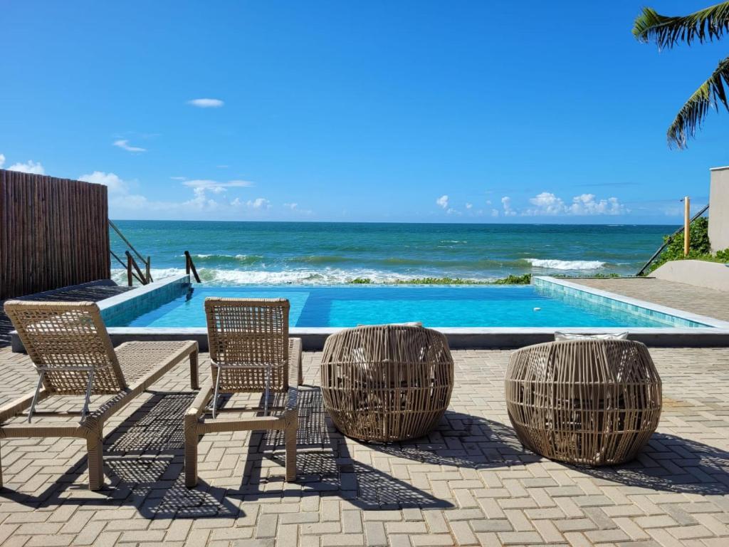 a group of chairs sitting next to a swimming pool at Pontal Flat 103 in Coruripe