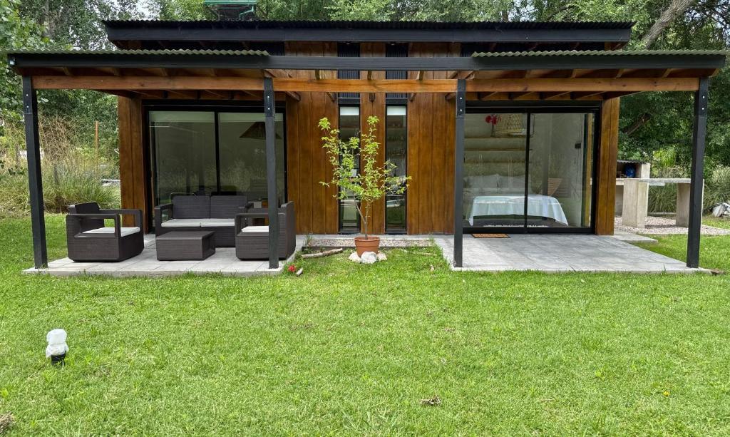 een huis met glazen deuren en een groen gazon bij Laguna y Tierra in Chascomús