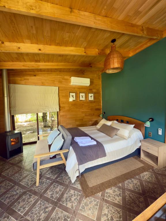 a bedroom with a large bed and a green wall at Siempre Verde in Puerto Tranquilo
