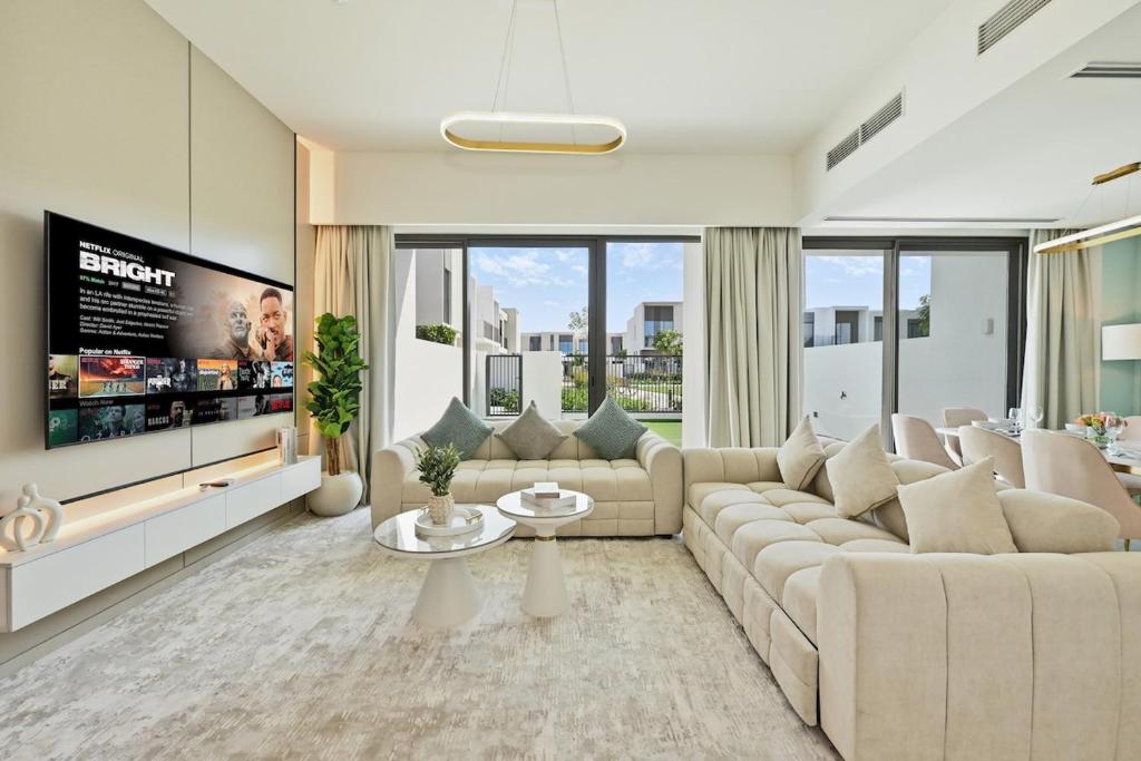een woonkamer met een grote bank en een tv bij Elegant 4BR Haven I Private & Peaceful in Dubai