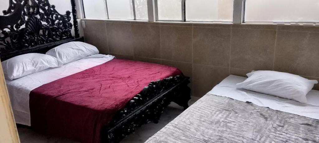 een slaapkamer met twee bedden en een raam bij casa de hospedaje urcunina in Pasto