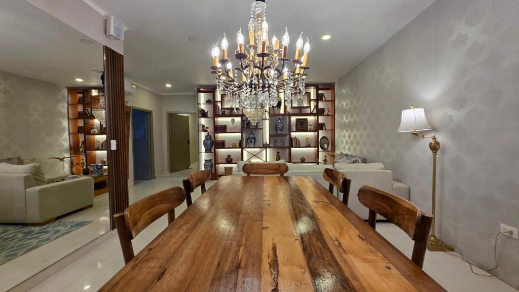 ein Esszimmer mit einem langen Tisch und einem Kronleuchter in der Unterkunft Hotel Casa La Tablada Aeropuerto in Cartagena de Indias