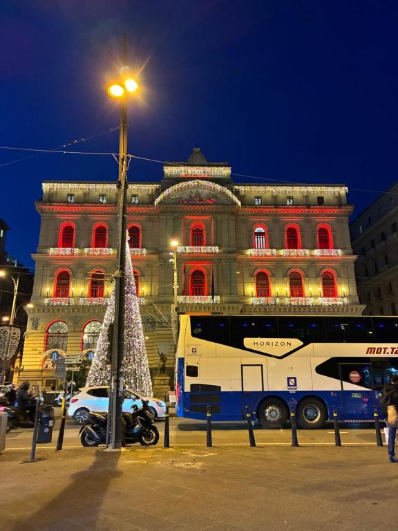 Ein Bus parkte vor einem Gebäude mit roten Lichtern in der Unterkunft Domus Gazzara -Napoli Centro Storico in Neapel
